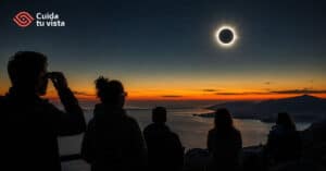 Grupo de personas observando la totalidad de un eclipse solar al atardecer