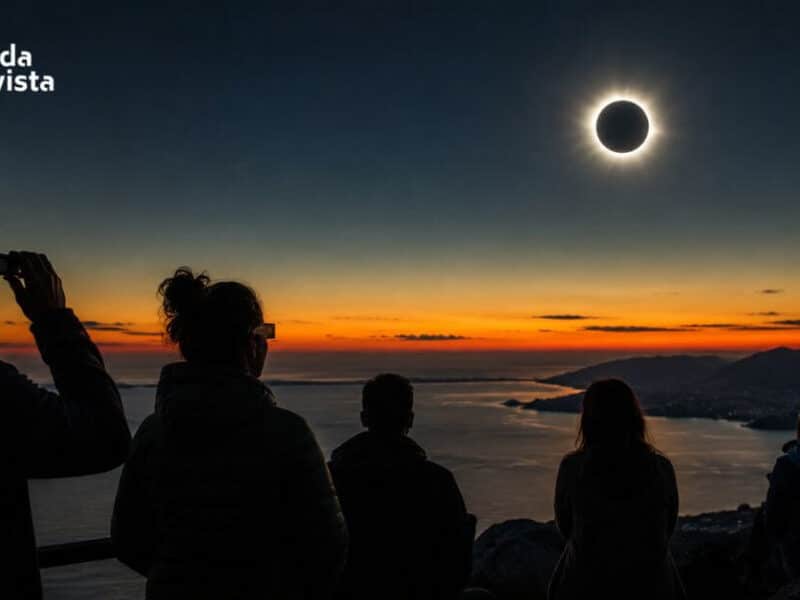 Grupo de personas observando la totalidad de un eclipse solar al atardecer